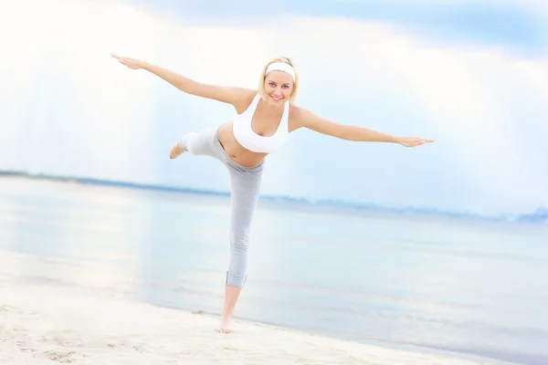 Giovane donna che si esercita sulla spiaggia — Foto Stock