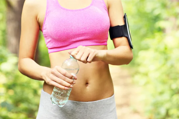 Frau öffnet Wasser im Wald — Stockfoto