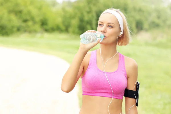 Wody pitnej joggingu w parku — Zdjęcie stockowe