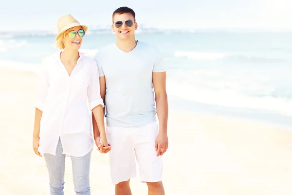 Pareja feliz caminando en la playa — Foto de Stock