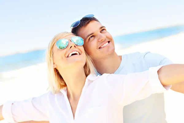 Pareja alegre en la playa — Foto de Stock