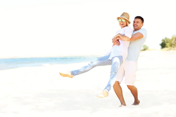 Casal feliz se divertindo na praia — Fotografia de Stock