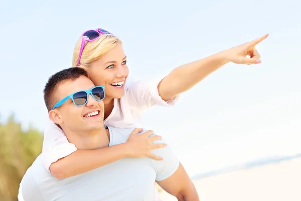 Paar wijzend op het strand — Stockfoto