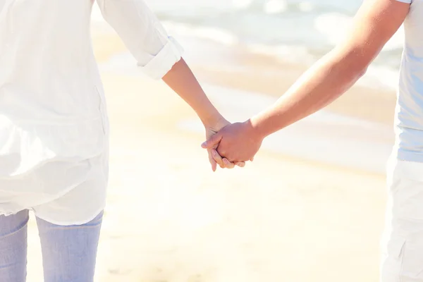 Paar hält Händchen am Strand — Stockfoto