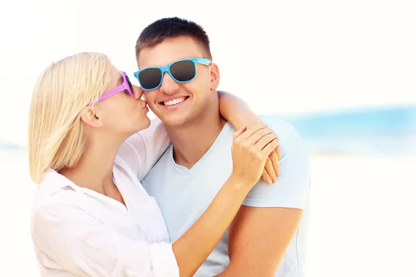 Mujer besando a un hombre en la playa Imagen de archivo