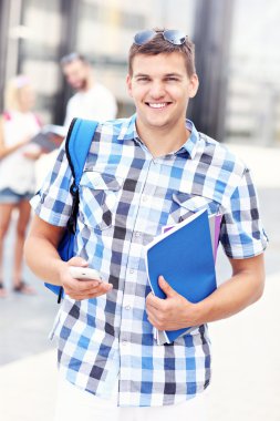 mutlu öğrenci kampus onun smartphone ile ayakta
