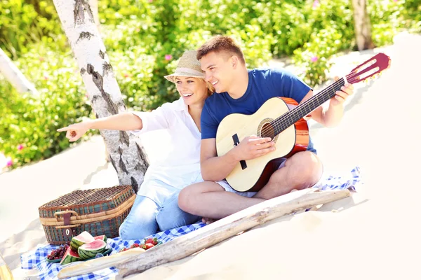 Szczęśliwa para na plaży z gitara — Zdjęcie stockowe