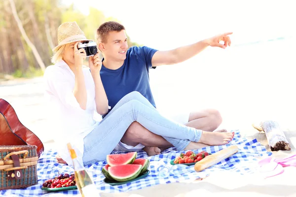 Jovem casal tirando fotos na praia — Fotografia de Stock