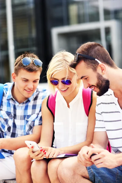 Grupo de amigos usando smartphone no campus — Fotografia de Stock