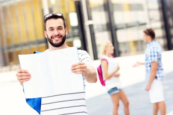 Jonge student permanent in de campus met een notitieblok openen — Stockfoto