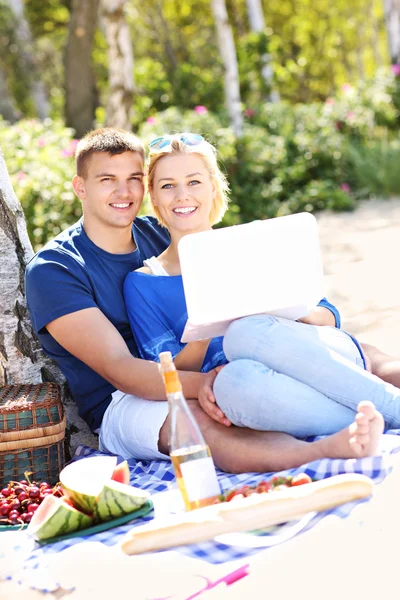 Jovem casal com laptop na praia — Fotografia de Stock