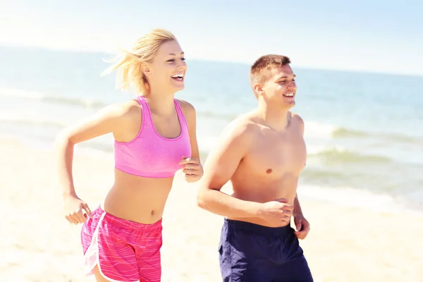 若いカップル、ビーチに沿ってジョギング — ストック写真