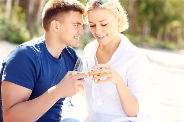 Romantisches Paar mit Champagner am Strand — Stockfoto