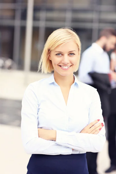 Glad affärskvinna stående utanför modern byggnad — Stockfoto