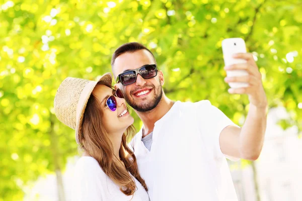 Mladý pár se selfie v parku — Stock fotografie