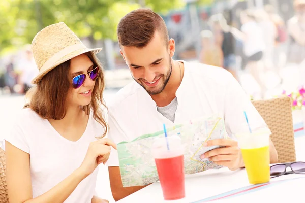 Schönes Paar schaut in einem Café auf die Landkarte — Stockfoto