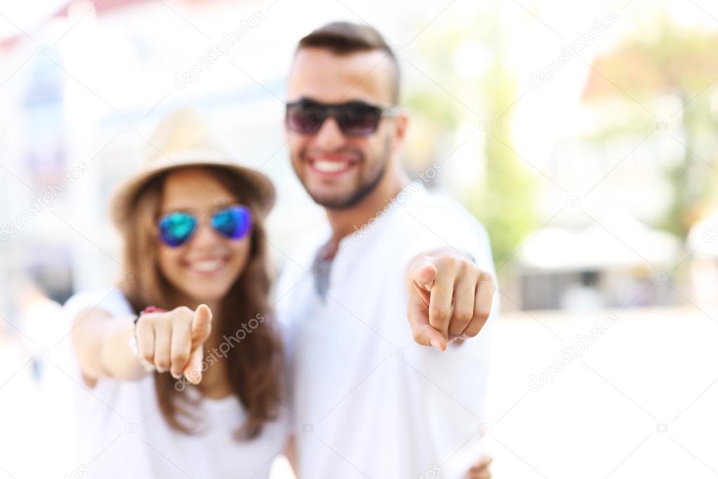 Blurry portrait of a couple pointing to the camera