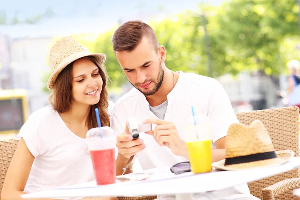 Tourists checking pictures in a cafe — Stock Photo, Image