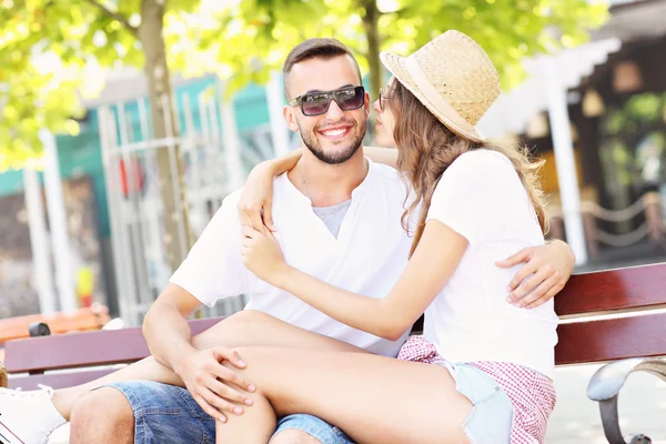 Счастливая пара целуется на скамейке — стоковое фото