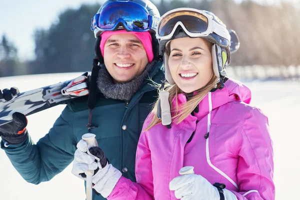 Pareja joven divirtiéndose mientras esquian en invierno — Foto de Stock