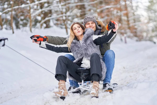 Paar plezier met slee op sneeuw in de winter — Stockfoto