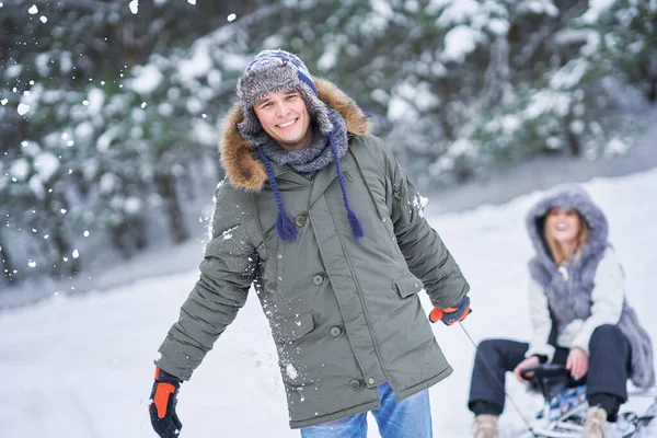 Casal se divertindo com trenó na neve no inverno — Fotografia de Stock