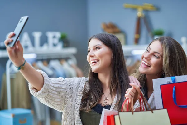 Groep van gelukkige vrienden tijdens het winkelen met de telefoon — Stockfoto