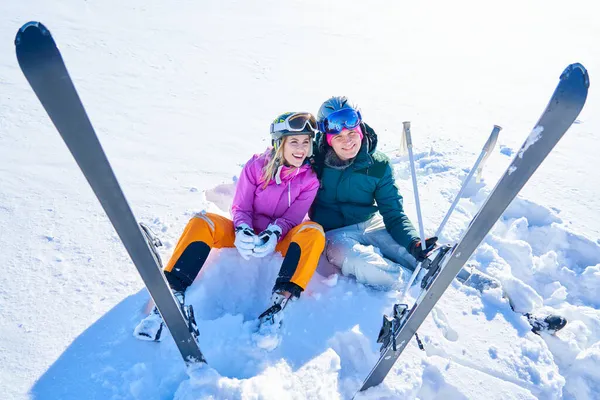 Młoda para bawiąca się podczas zimowych nart — Zdjęcie stockowe