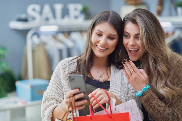 Gruppo di amici felici durante lo shopping con il telefono — Foto Stock