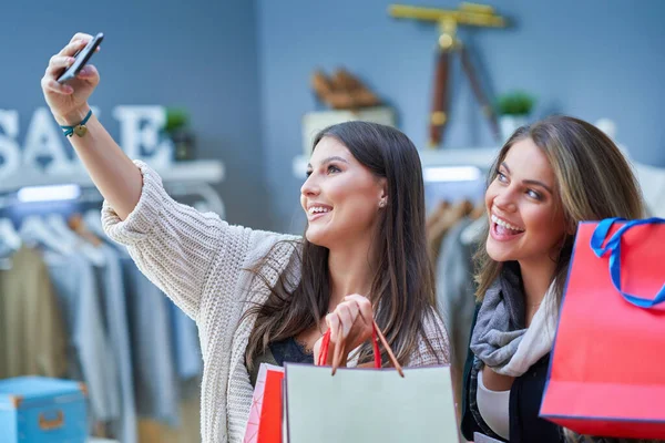 Group of happy friends during shopping with phone — Stock Photo, Image
