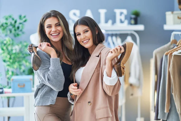 Дві щасливі дівчата на шопінгу тримають взуття — стокове фото