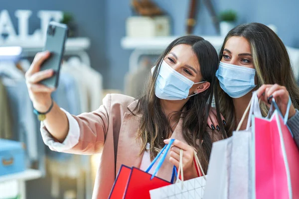 Meninas em compras usando máscaras tomando selfie — Fotografia de Stock