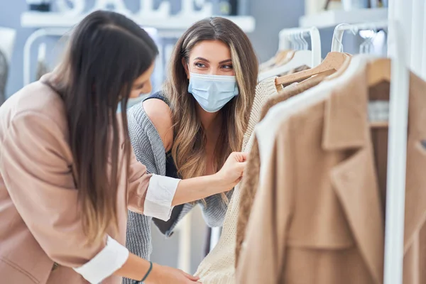 Девушки в магазинах в одежде в масках — стоковое фото