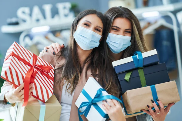 Ragazze a fare shopping in negozio con vestiti che indossano maschere — Foto Stock