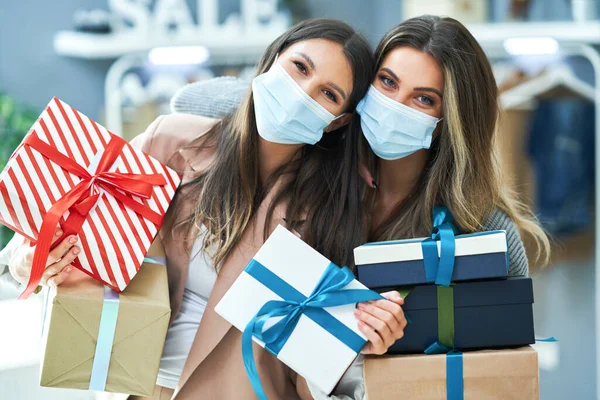 Meninas em compras na loja com roupas usando máscaras — Fotografia de Stock