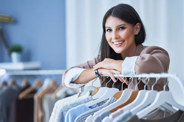 Ung kvinna som butikschef med kläder — Stockfoto