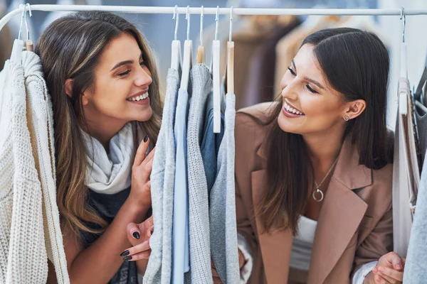 Dos chicas felices en la tienda de ropa durante las compras —  Fotos de Stock
