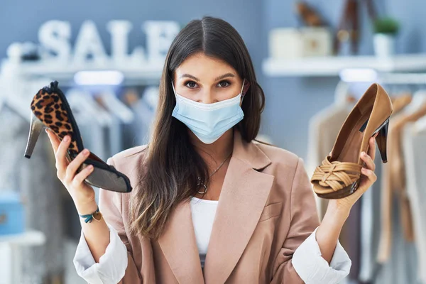 Fiatal szép lány a boltban vásárlás közben cipőt visel maszk — Stock Fotó