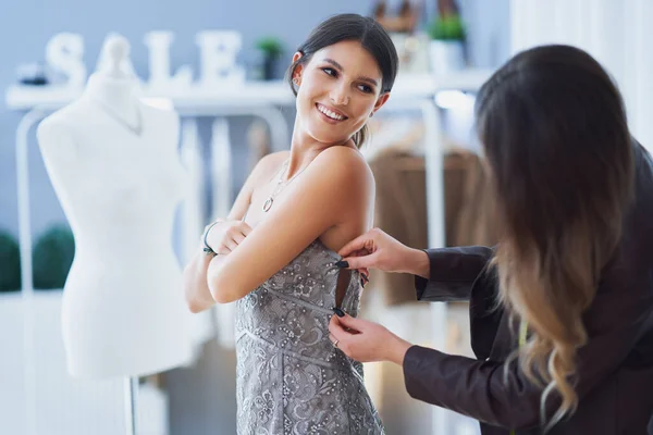 Vrouw in jurk in kledingwinkel met kleermaker — Stockfoto