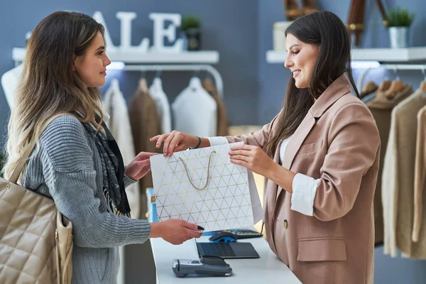 Mulher vendedor e comprador na loja de roupas — Fotografia de Stock