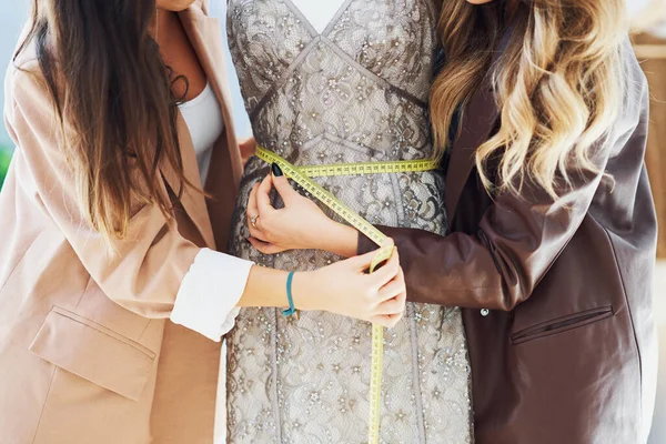 Twee vrouwen kleermakers proberen jurk op etalagepop — Stockfoto