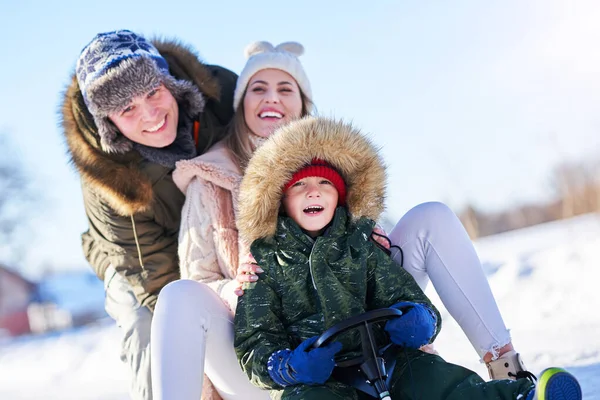 Miła szczęśliwa rodzina bawiąca się na zimowym śniegu — Zdjęcie stockowe