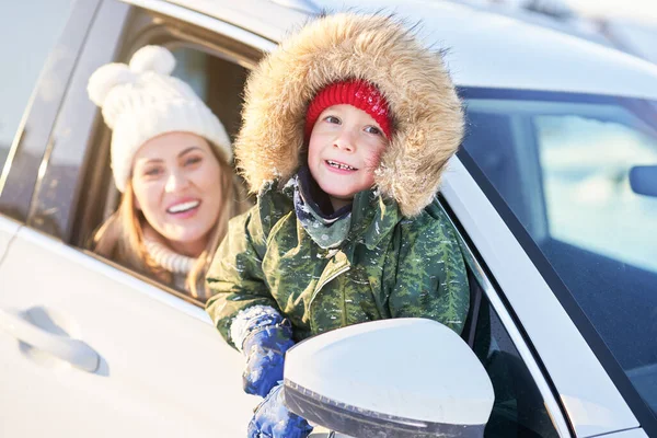 Jovem menino feliz com a mãe no carro durante o inverno — Fotografia de Stock