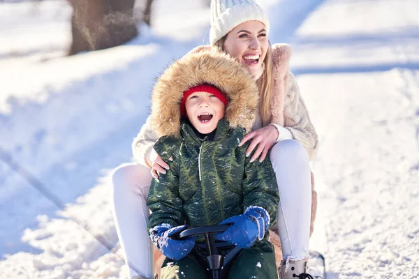 Гарна щаслива сім'я розважається на зимовому снігу — стокове фото