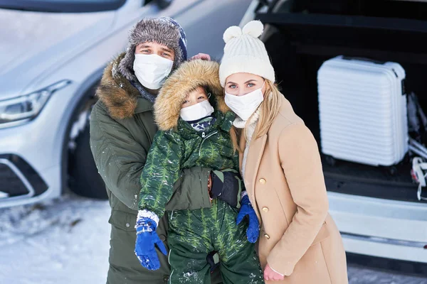 Giovane famiglia durante il viaggio invernale tronco d'auto in bacground — Foto Stock