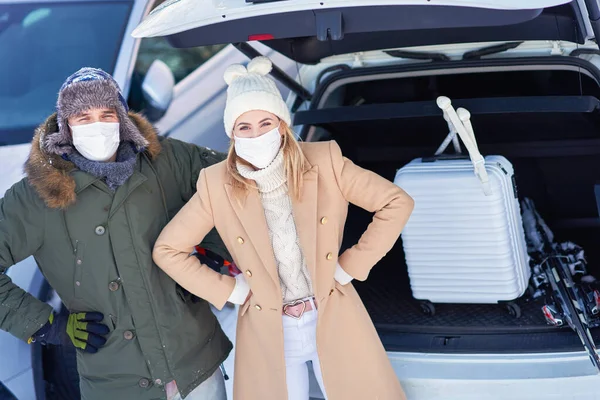 Giovane famiglia durante il viaggio invernale tronco d'auto in bacground — Foto Stock