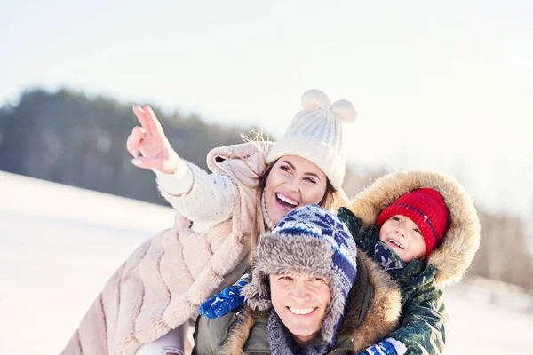 Família feliz agradável se divertindo na neve de inverno — Fotografia de Stock