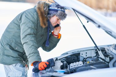Man having problem with car during snowy winter