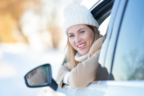 Szczęśliwa kobieta jazdy samochodem w śniegu zima — Zdjęcie stockowe