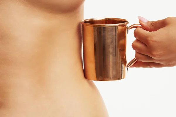 Woman holding copper copper utensils in front of body skin — Stockfoto